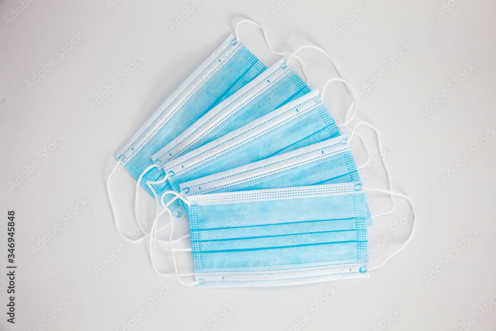 Blue protective medical masks lie on a white background Blue protective medical masks lie on a white background