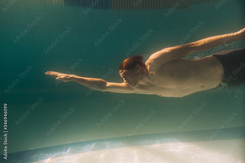 Male swimming instructor under water