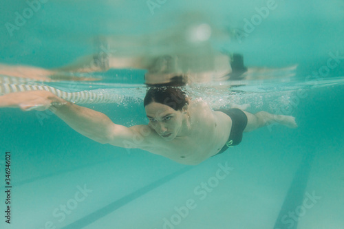 Male swimming instructor under water