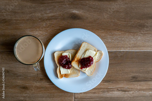 Obraz na płótnie Cup of coffe with milk and two slices of toasted sandwich with Butter and Raspberry Jam. Breakfast with coffee. Top view. Free space for text. w salonie