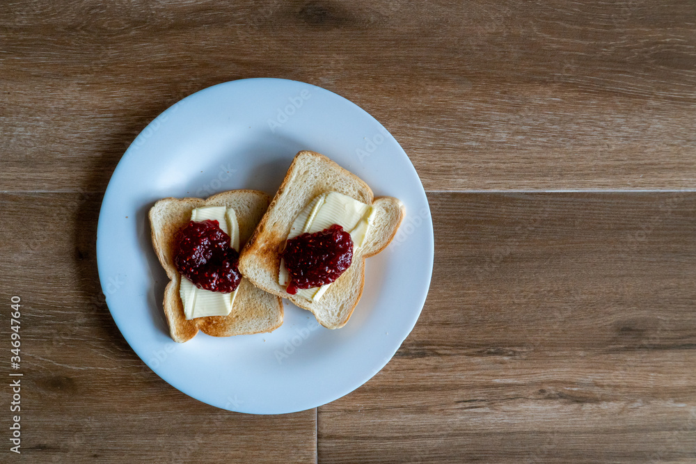 Two slices of toasted sandwich with Butter and Raspberry Jam. Breakfast. Top view. Free space for text.