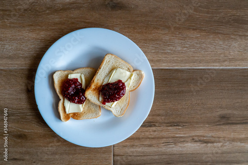 Obraz na płótnie Two slices of toasted sandwich with Butter and Raspberry Jam. Breakfast. Top view. Free space for text. w salonie