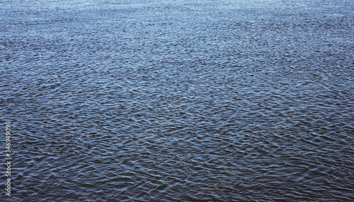 Water surface background. Dark blue water pattern, deep open water with light wind ripples, blank nature concept image