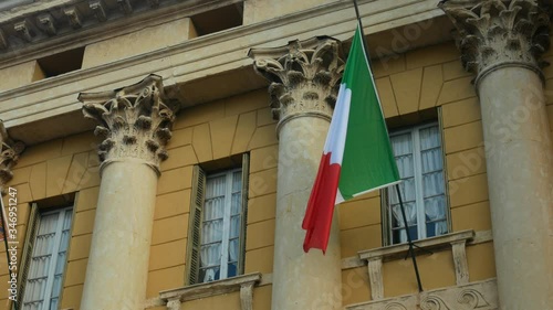 Close-up of Italian national flag fluttering in the wind on the ancient building with columns