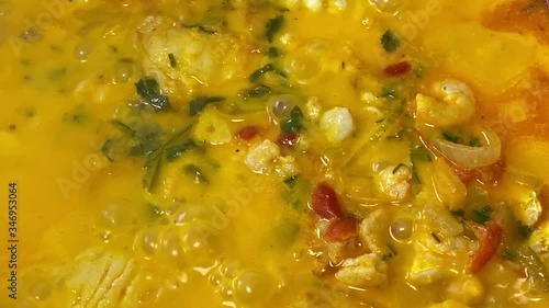 Cooking a moqueca dish. Brazilian traditional food made with fish and shrimp, coconut milk and azeite de dende.