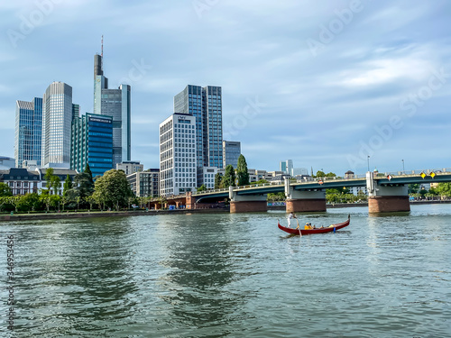 Frankfurt, Germany - 08th May 2020: A german photographer visiting Frankfurt, discovering a gondola on the river Main with the skyline in the background.
 photo