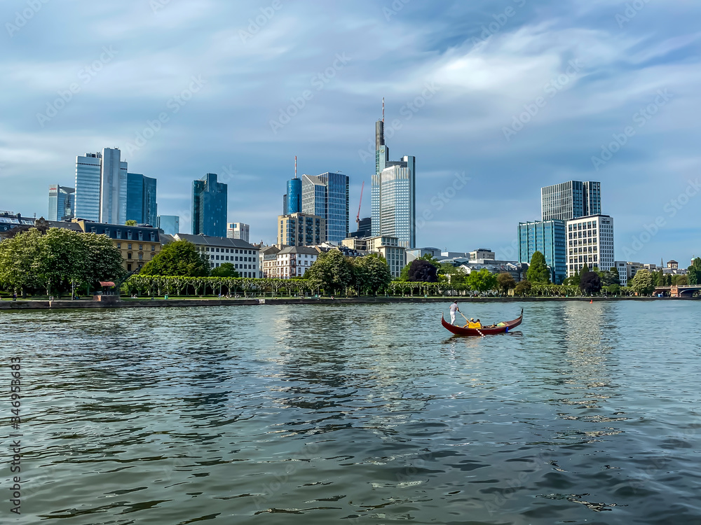 Frankfurt, Germany - 08th May 2020: A german photographer visiting Frankfurt, discovering a gondola on the river Main with the skyline in the background.

