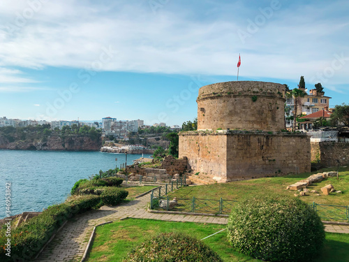 A horizontal image of ancient Hidirlik Tower Castle in Kaleici, Antalya, Turkey. Landscape of Antalya old town and Mediterranean sea. photo