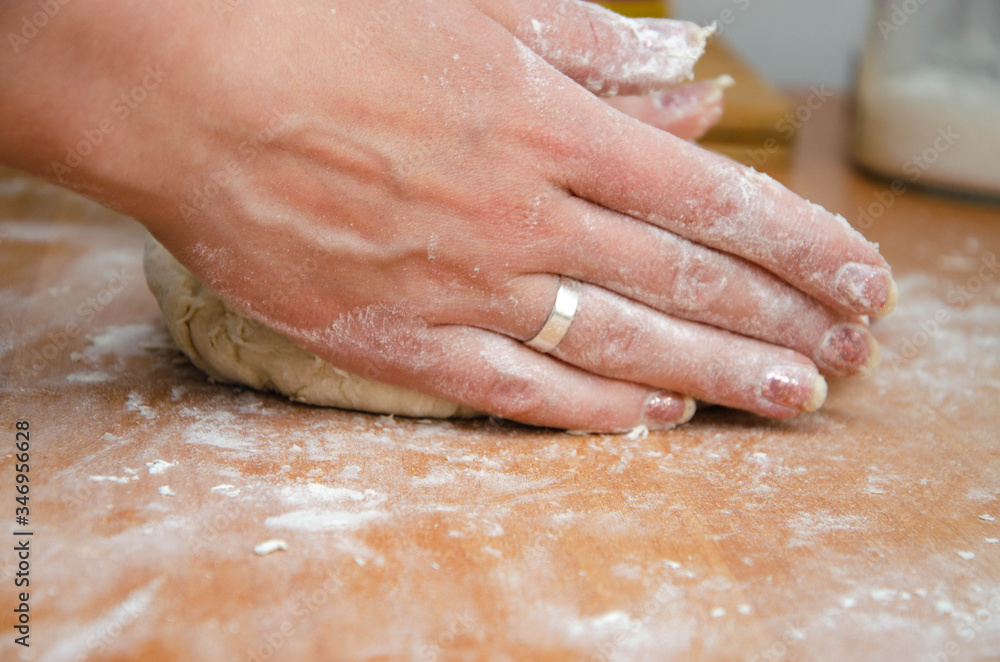 Female hands knead, knead the pizza dough. Dough, flour, cook, pizza. Girl rolls rolling pin dough Female hands knead, knead the pizza dough. Dough, flour, cook, pizza. Girl rolls rolling pin dough
