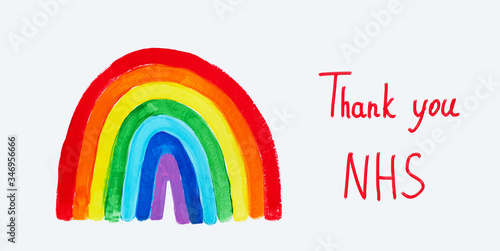 Thank to NHS lettering. Childrens hand drawing rainbow on paper. Greating card for nurses. photo