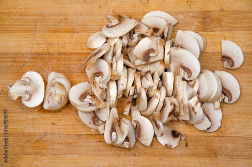 Mushrooms champignon sliced on board. Mushrooms in macro. Hand cuts mushrooms with a knife