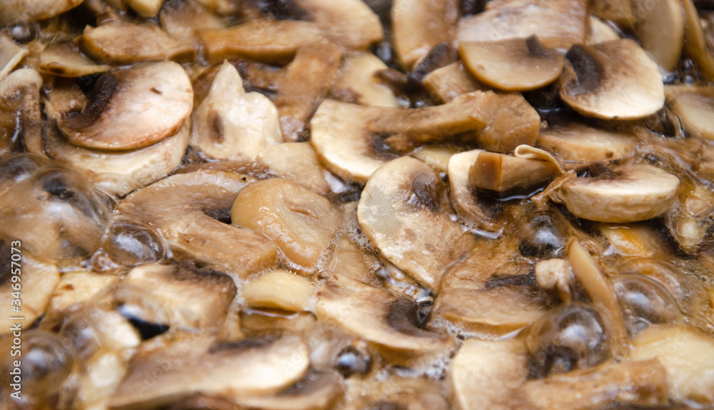 Chopped champignon mushrooms are fried in a pan. Pizza  Mushrooms