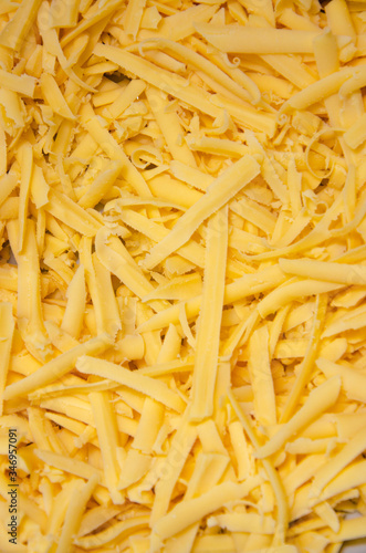 Grated hard cheese for homemade pizza. Russian, Dutch cheese. Grated cheese in  macro