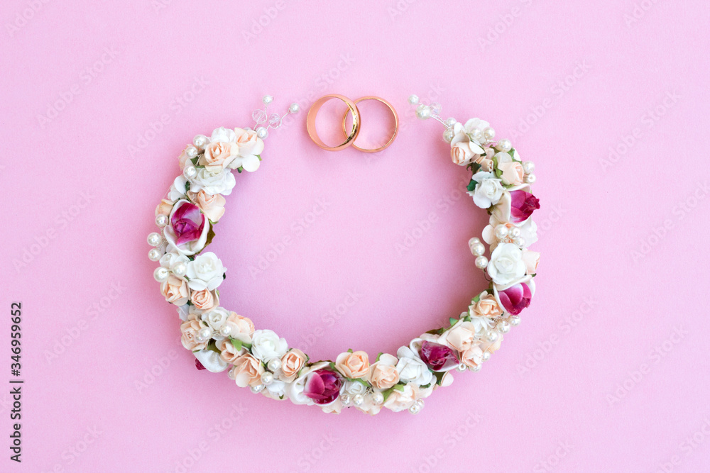 Gold wedding rings on a background of flowers. Flowers in the form of a garland. Perfect for wedding invitations and greeting cards. Gold wedding rings on a background of flowers. Flowers in the form of a garland. Perfect for wedding invitations and greeting cards.