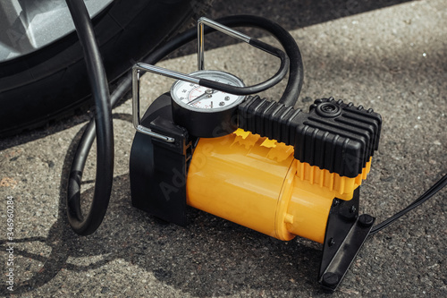Automobile compressor. Electric pump inflates a car wheel close-up