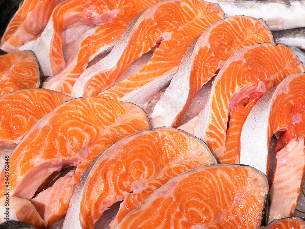 Chilled salmon steaks laid on ice store counter. Slice, steak, peace of red  fish. Fresh cooled trout slices, chum. Salmon meat in supermarket and  seafood store. Healthy diet concept. Stock Photo