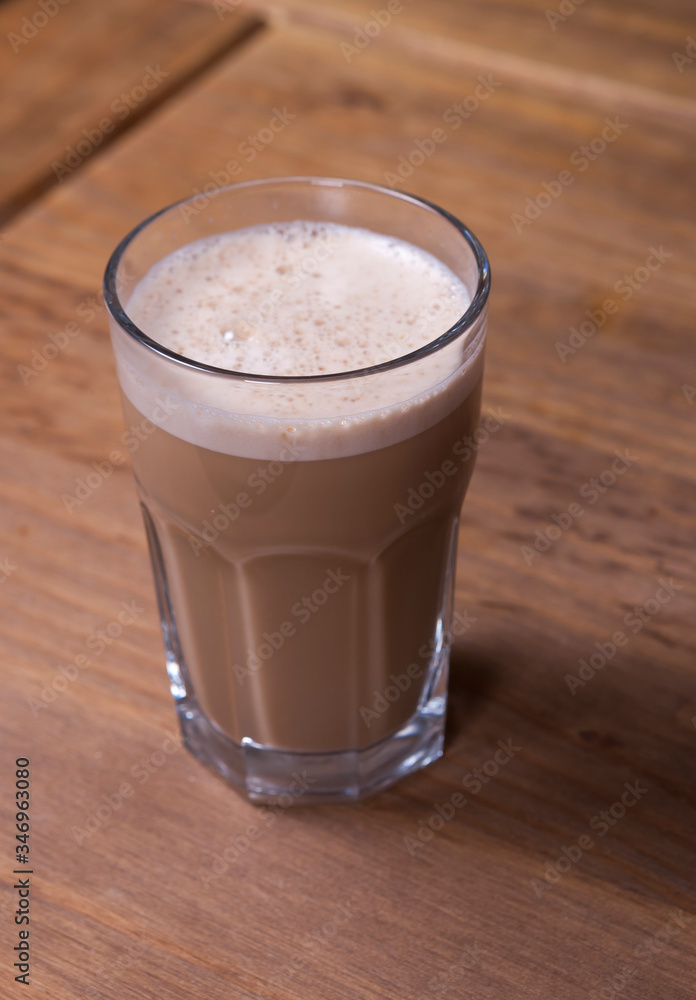 glass of cappuccino on a wooden table glass of cappuccino on a wooden table