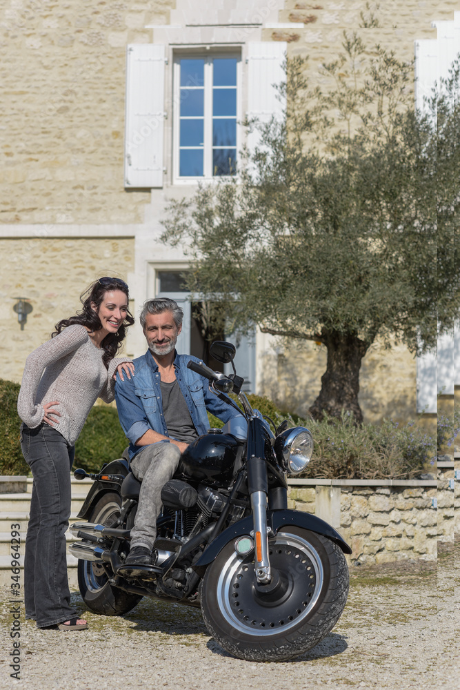 husband introduces his new custom motorcycle to his wife