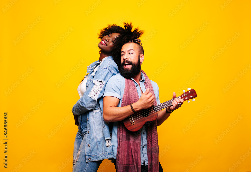 Happy young man with woman in studio playing ukulele Happy young man with woman in studio playing ukulele