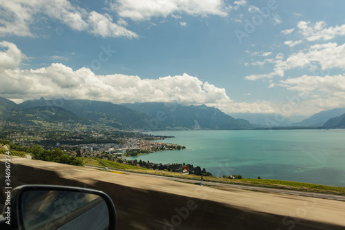 View of the amazing Lake Geneva from highway. Country houses surrounded by green vineyards. Area near Mont Pelerin - mountain of the Swiss Plateau, overlooking Lake Geneva in the canton of Vaud
