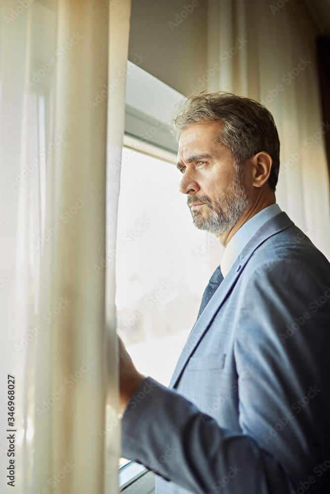 Portrait of businessman looking out of window Portrait of businessman looking out of window