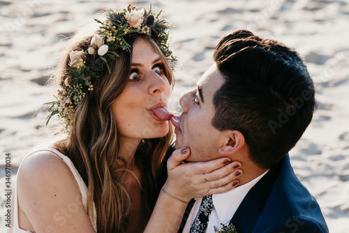 Bridal couple tongue on tongue, pulling funny faces