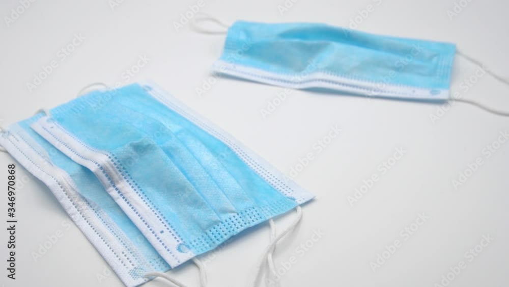 Slow motion of three surgical masks on white background. Slow motion of three surgical masks on white background.