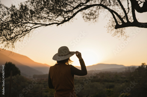 Woman enjoying the view of the sunset in the countryside, Orgiva, Andalusia, Spain photo