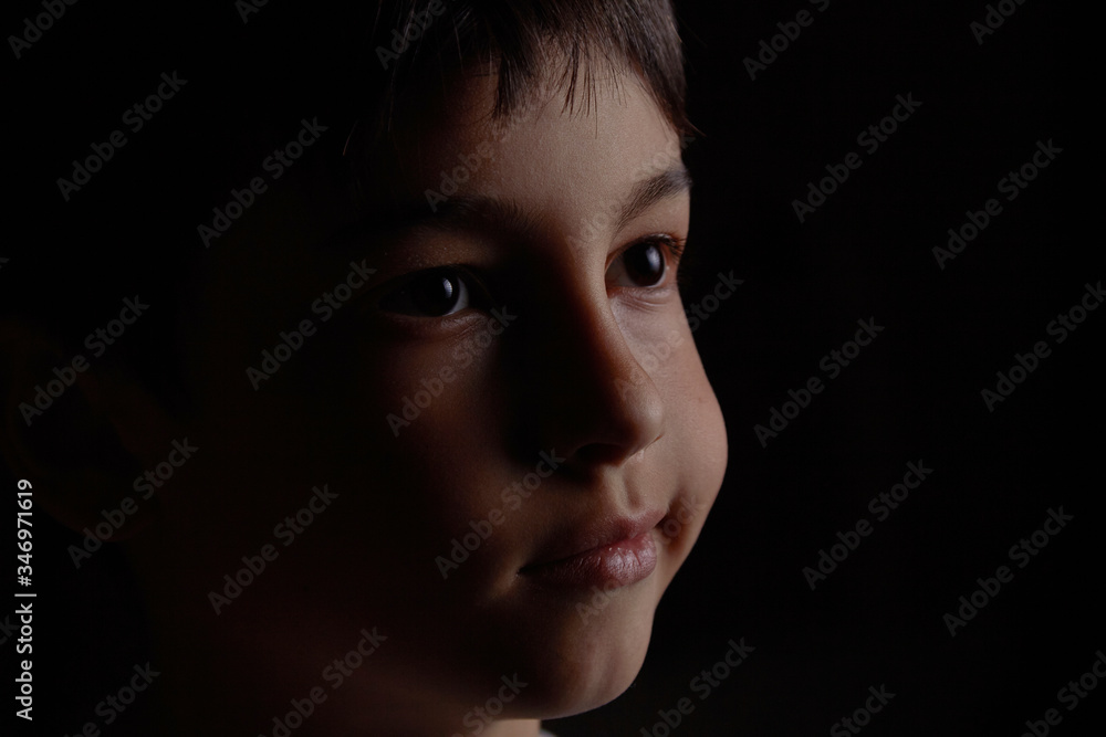 portrait of a boy on a dark background close up face portrait of a boy on a dark background close up face