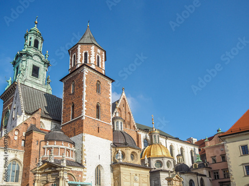 Beautiful architecture and rooftops of Wawel Castle with blue sky in background.