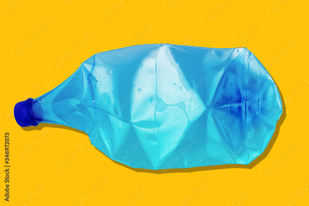 Obraz premium crushed blue plastic bottle on yellow background