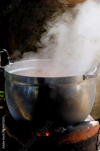 White smoke from a hot cooking pot in an style kitchen area with dark background 