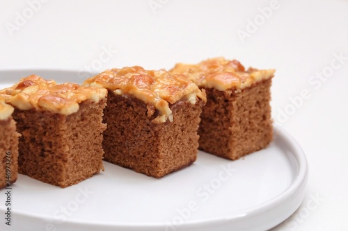 Close up a group of toffee cake pieces on a plate with white background 