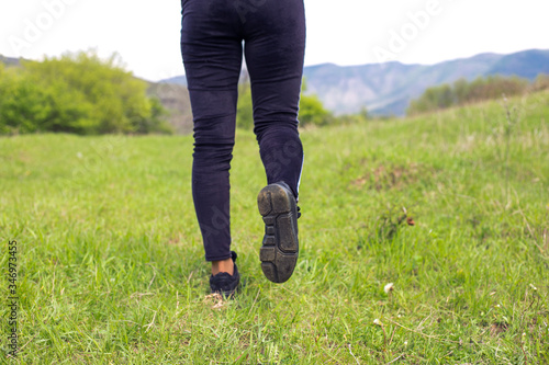 Young woman running on morning forest trail close up