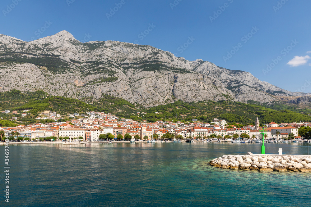 Makarska in Dalmatia, Croatia. View from the sea on a sunny day in the summer and a blue sky. A famous place with beaches and the Biokovo mountain. Holiday destination at the Mediterranean coast