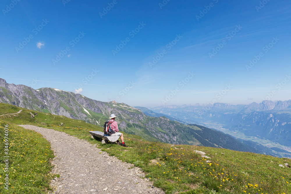 Switzerland, St Gallen Canton, Glarus Alps, Man taking a break on the Panoramic hiking trail in the Tectonic Arena Sardona Switzerland, St Gallen Canton, Glarus Alps, Man taking a break on the Panoramic hiking trail in the Tectonic Arena Sardona