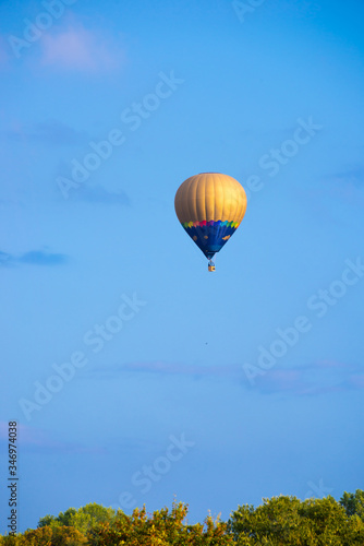 Colorful hot air balloon flying in blue sky © Maresol
