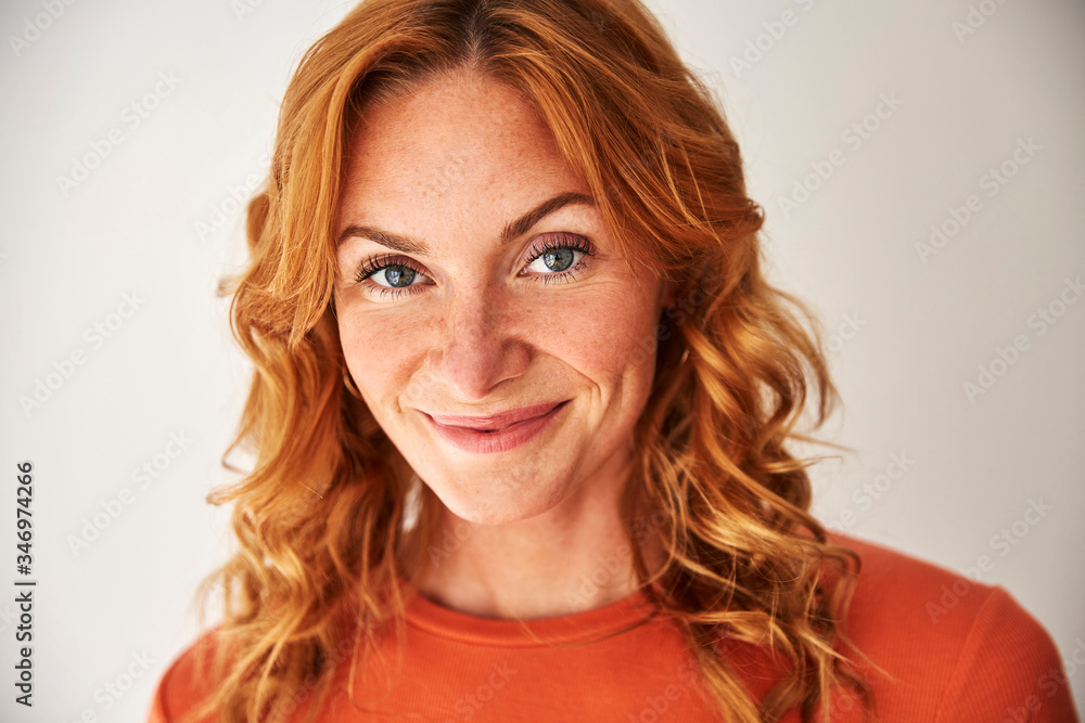 Portrait of smiling red-haired woman looking at camera Portrait of smiling red-haired woman looking at camera