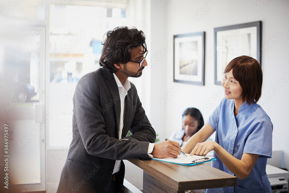 Patient at reception desk of a dental practice Patient at reception desk of a dental practice
