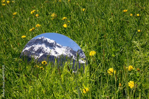 Round mirroe lying in grass, reflecting the mountains of Val Badia, Alto Adige, Ilaty photo