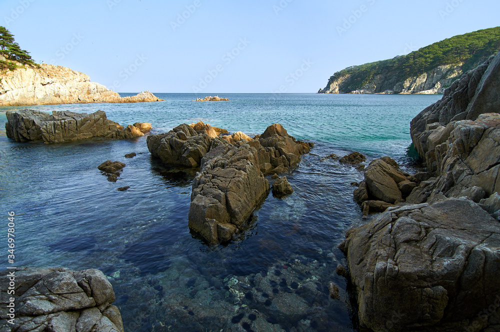 Sea coast with clear water. Stones and sea urchins at the bottom.