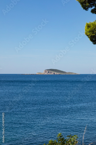 Bobara small island near Cavtat, Dalmatia Croatia on a sunny day in summer surrounded by crystal clear blue sea and sky. Unique shaped islet southern of Dubrovnik photo