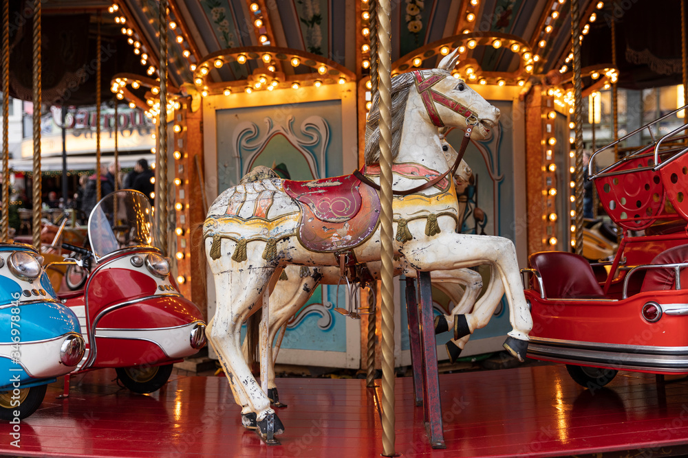 Old vintage horse carousel ride in the city center of Eindhoven, the Netherlands on the Markt, an authentic retro merry go round with lights