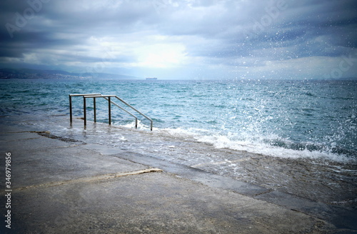Waterfront on the stormy weather with seawater and waves that hits the coast