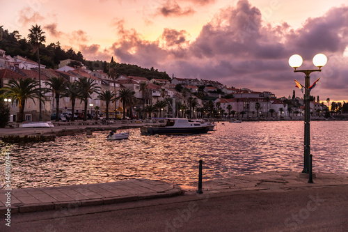 Korcula island shot from the harbour during sunset in summer. Beautiful old venetian town with mountains and a purple sky with deep pink clouds creating an idyllic scenery. Holiday destination © Lea