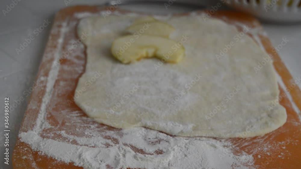 Rolled wheat dough with apples and rolling pin on a table Rolled wheat dough with apples and rolling pin on a table