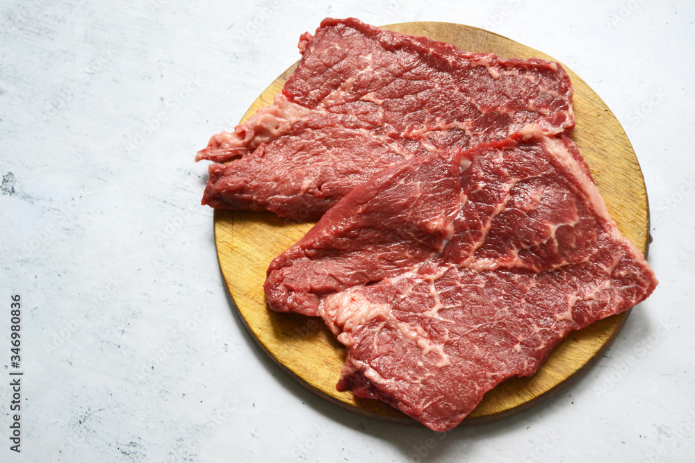 Tenderloin of fresh beef meat on a wooden board on a white background