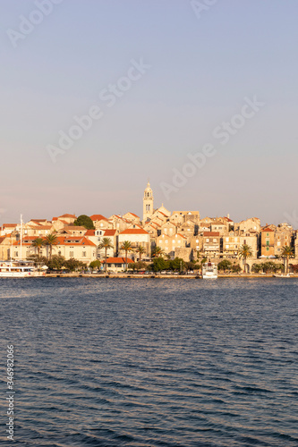 Korcula island with the old city walls, view from the sea on a sunny day during sunset. Clear adriactic sea, the mediterranean coast of Croatia, Europe. Seascape creating an idyllic scenery © Lea