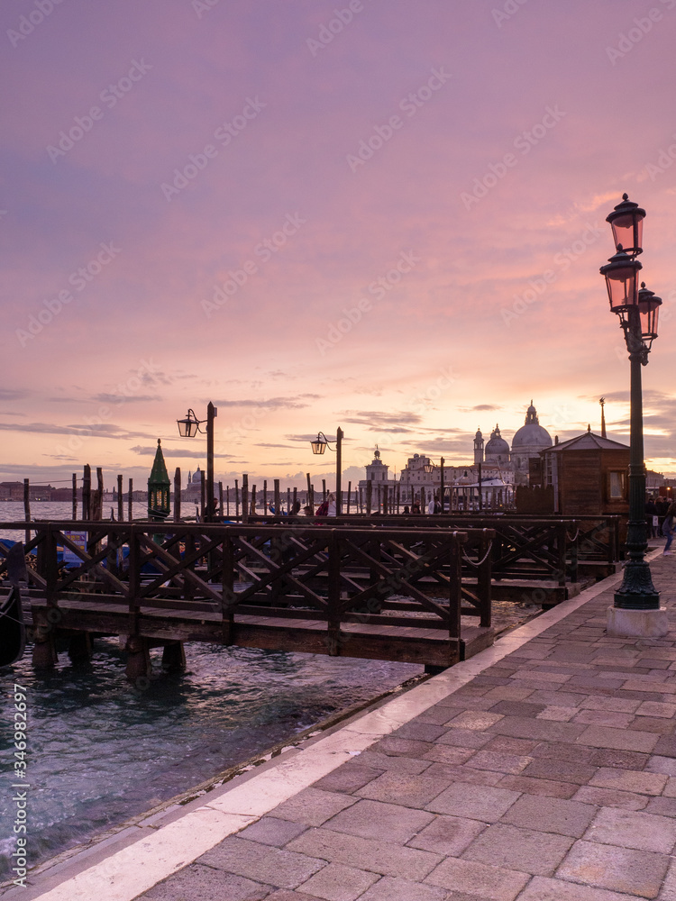 Pink sunset from San Marco square, Venice, Italy, with the gondolas and the Grand Canal in the background
