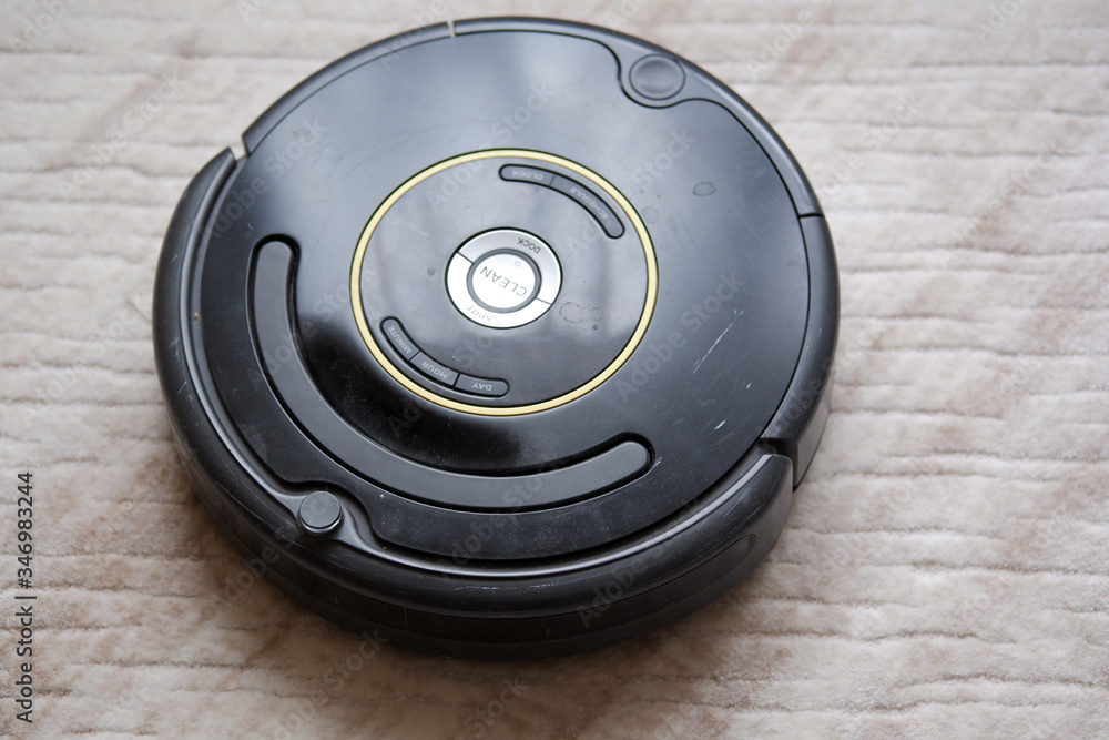 close-up of an robotic vacuum cleaner on carpet smart cleaning technology. Used old robotic vacuum cleaner. close-up of an robotic vacuum cleaner on carpet smart cleaning technology. Used old robotic vacuum cleaner.